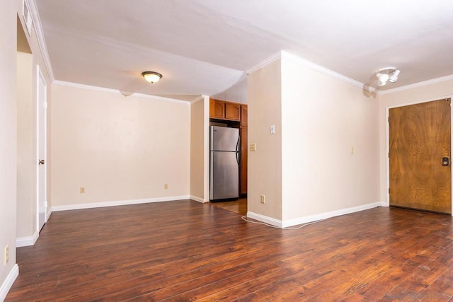 spare room featuring ornamental molding and dark hardwood / wood-style floors