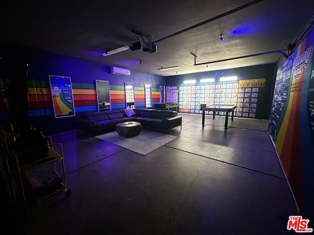 recreation room featuring concrete flooring and a wall mounted air conditioner