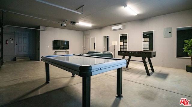 recreation room featuring an AC wall unit, concrete floors, and electric panel