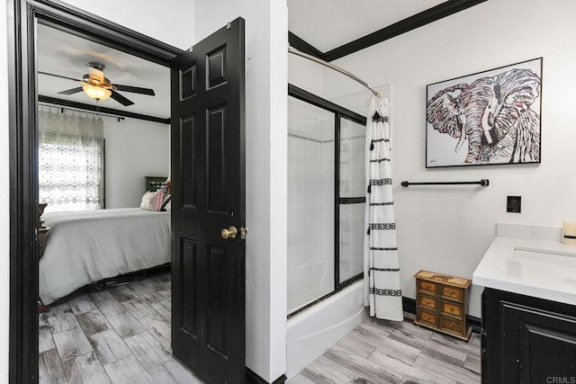 bathroom with hardwood / wood-style flooring, ornamental molding, vanity, ceiling fan, and shower / bath combo