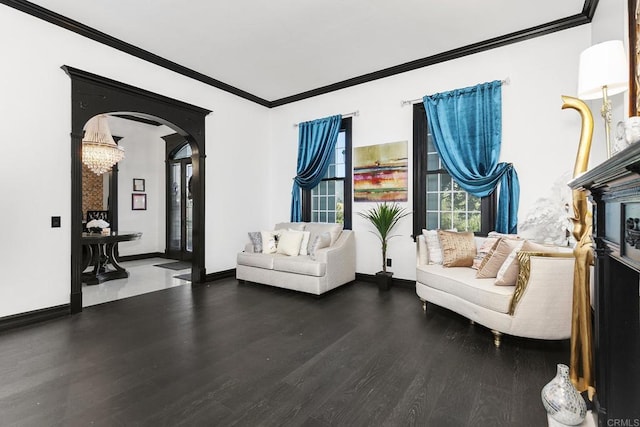 sitting room with ornamental molding, wood-type flooring, and a notable chandelier