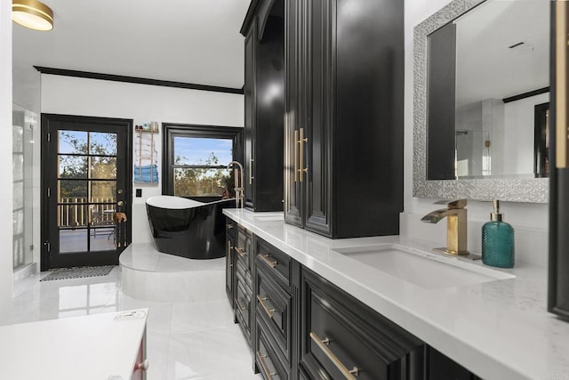 bathroom with ornamental molding, vanity, and a bathing tub