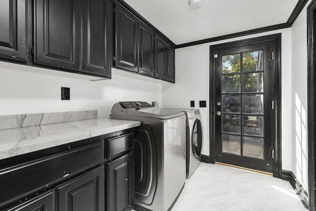 laundry room featuring crown molding, cabinets, and washer and clothes dryer