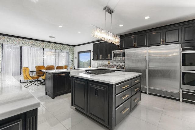 kitchen with light stone counters, built in appliances, a kitchen island, pendant lighting, and decorative backsplash