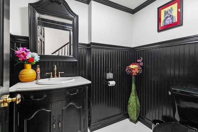 bathroom with vanity, ornamental molding, and toilet