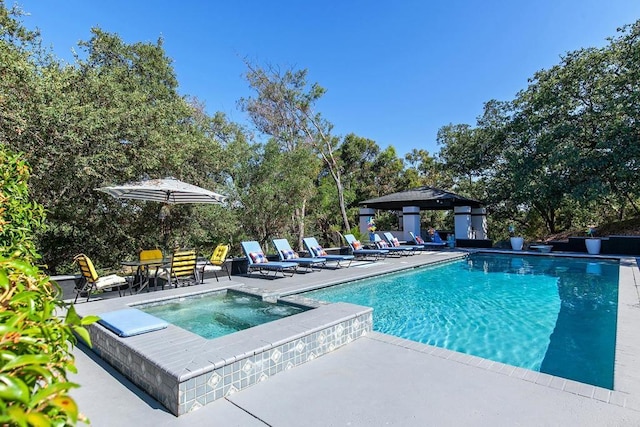 view of pool featuring a patio area and an in ground hot tub