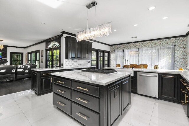 kitchen with decorative light fixtures, ornamental molding, a kitchen island, stainless steel appliances, and backsplash