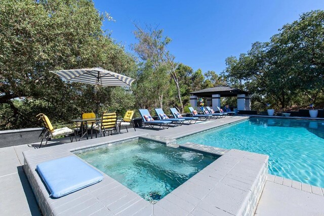 view of pool featuring an in ground hot tub