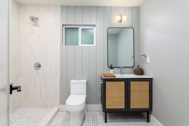 bathroom with vanity, toilet, and tiled shower