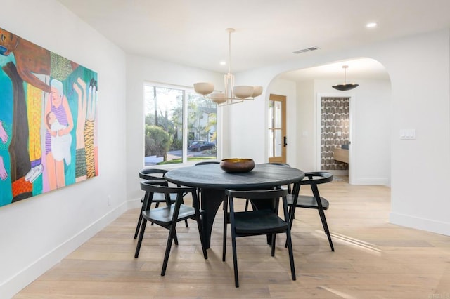 dining space featuring an inviting chandelier and light hardwood / wood-style flooring