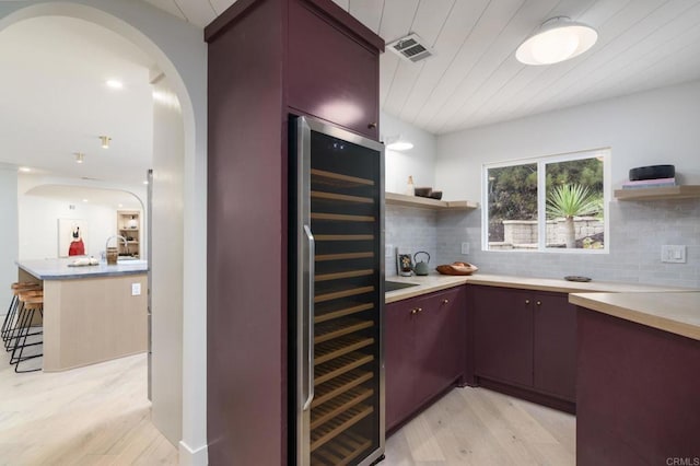 interior space featuring wine cooler, backsplash, wood ceiling, and light hardwood / wood-style floors