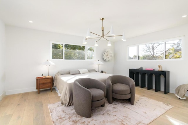 bedroom with a chandelier and hardwood / wood-style floors