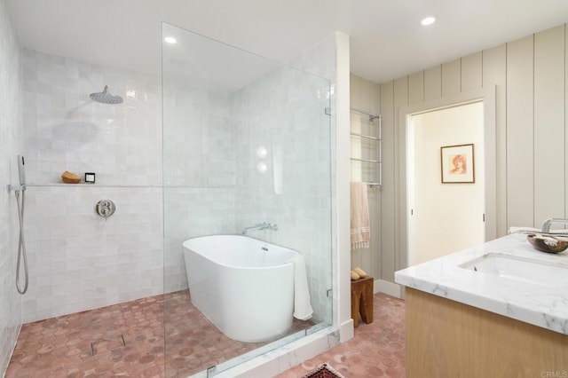 bathroom featuring vanity, separate shower and tub, tile patterned flooring, and tile walls