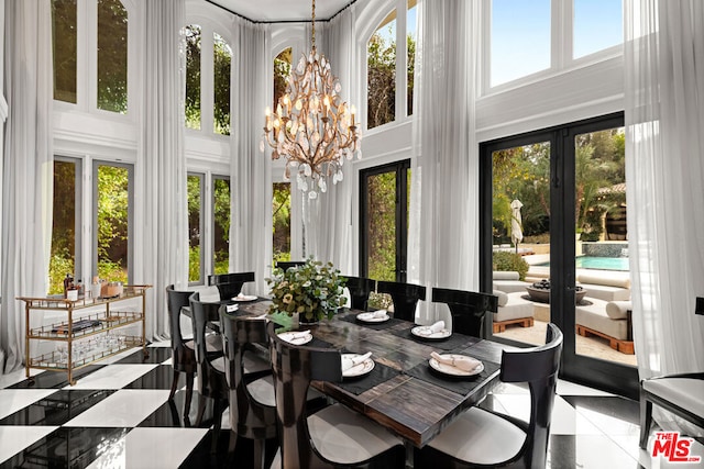 sunroom featuring an inviting chandelier and french doors