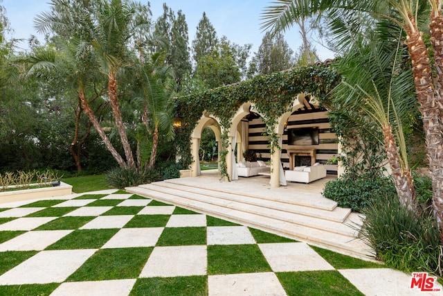 wooden deck featuring exterior fireplace and a patio area