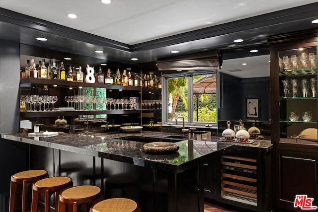 bar featuring sink, wine cooler, and dark stone counters