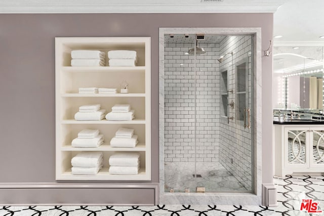 bathroom with crown molding, a shower with shower door, and built in shelves