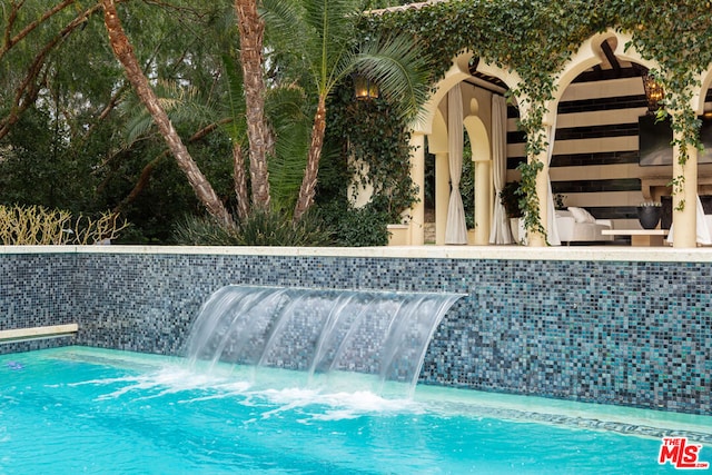 view of pool with pool water feature