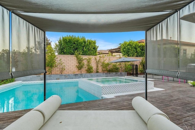 view of swimming pool featuring an in ground hot tub and a deck