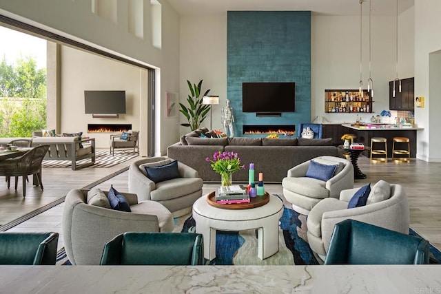 living room with a high ceiling, wood-type flooring, and a fireplace