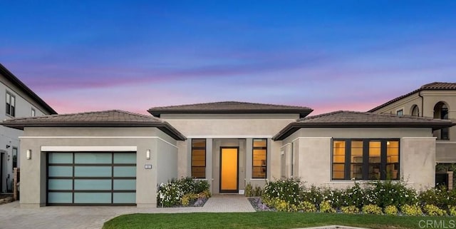 view of front facade with a garage and a lawn