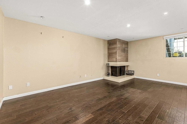 unfurnished living room featuring dark hardwood / wood-style floors and a multi sided fireplace