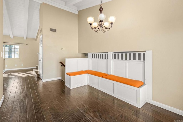 unfurnished dining area with beamed ceiling, dark wood-type flooring, and a notable chandelier