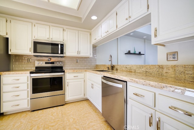 kitchen featuring white cabinetry, stainless steel appliances, sink, and backsplash