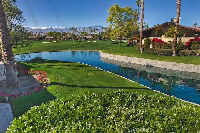 view of community featuring a water and mountain view and a lawn