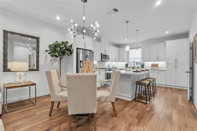 dining area featuring light hardwood / wood-style flooring and a chandelier