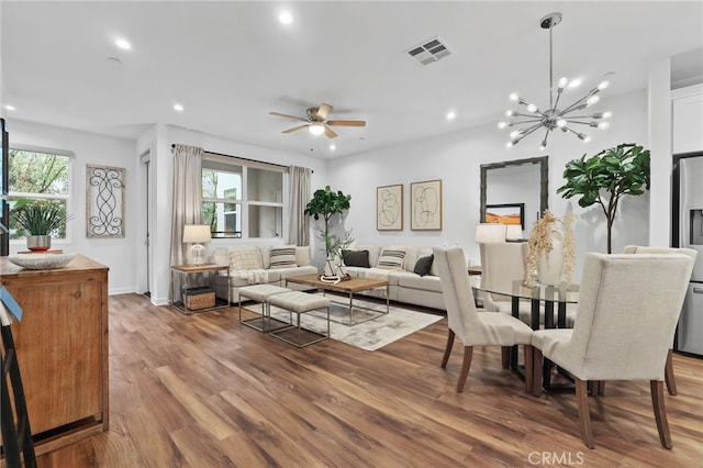 interior space featuring hardwood / wood-style flooring and ceiling fan with notable chandelier