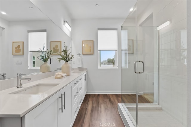 bathroom featuring vanity, hardwood / wood-style floors, and a shower with shower door