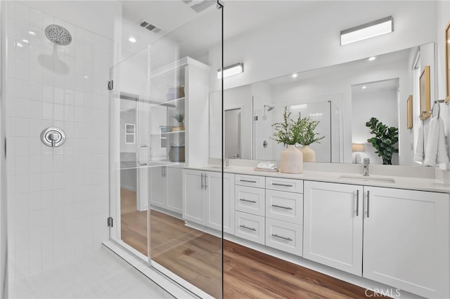 bathroom featuring vanity, hardwood / wood-style flooring, and a shower with door