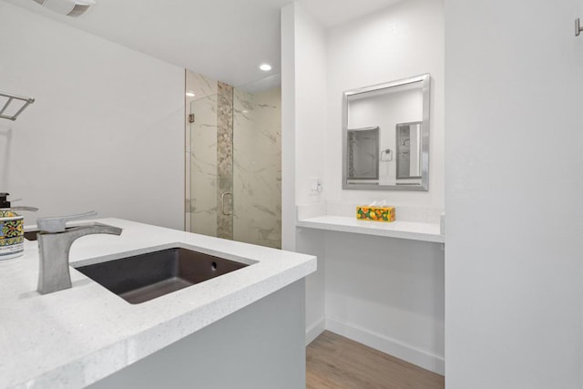 bathroom with an enclosed shower, vanity, and wood-type flooring