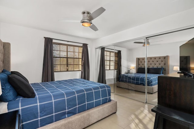 tiled bedroom with ceiling fan and a closet