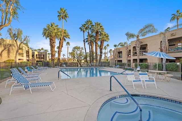 view of pool with a hot tub and a patio