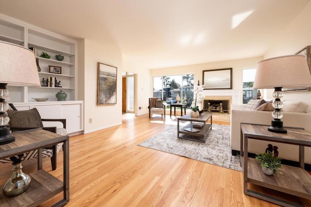 living room featuring built in shelves and light hardwood / wood-style flooring