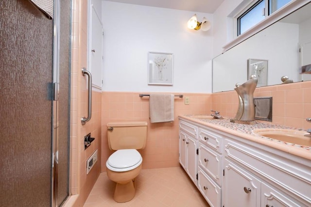 bathroom with tile walls, vanity, an enclosed shower, tile patterned floors, and toilet