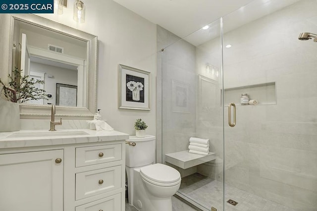 bathroom with vanity, an enclosed shower, and toilet