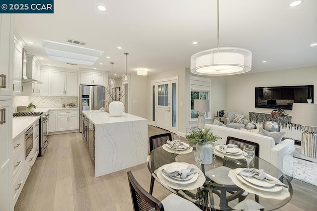 dining room featuring sink and light hardwood / wood-style floors