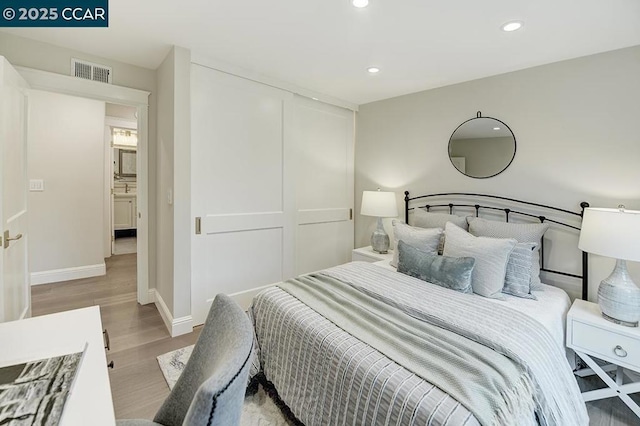 bedroom featuring sink, light hardwood / wood-style floors, and a closet