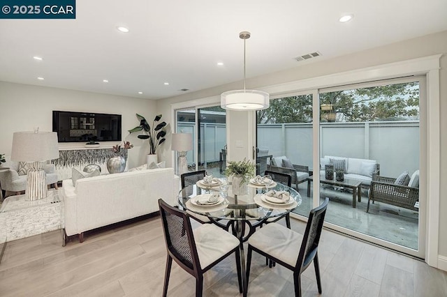 dining space with light hardwood / wood-style flooring