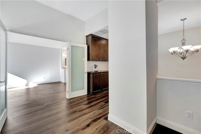 interior space with dark wood-type flooring and an inviting chandelier