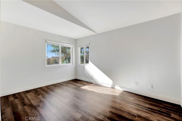 empty room with lofted ceiling and dark hardwood / wood-style floors