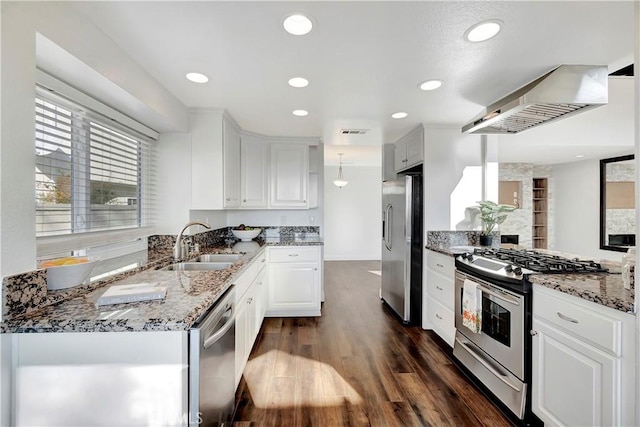 kitchen with sink, appliances with stainless steel finishes, white cabinetry, hanging light fixtures, and extractor fan