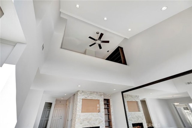 interior details featuring ceiling fan and a fireplace