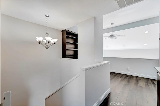 corridor with an inviting chandelier and hardwood / wood-style floors