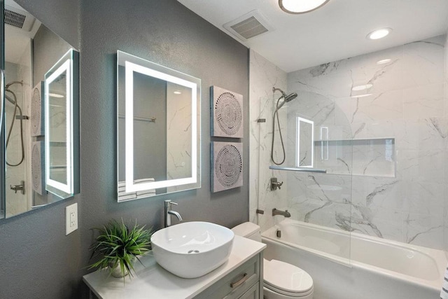 full bathroom featuring vanity, tiled shower / bath combo, and toilet