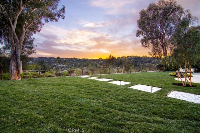 yard at dusk featuring a rural view