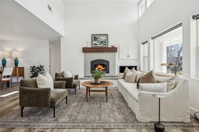 living room with hardwood / wood-style flooring and a towering ceiling